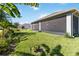 Exterior view of screened lanai with lush, well-maintained lawn, trees, and plants at 1813 Castleton Dr, St Cloud, FL 34771
