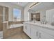 Bright bathroom featuring double sinks, soaking tub, enclosed shower, and a large mirror at 1813 Castleton Dr, St Cloud, FL 34771