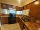 Condo kitchen with brown cabinets, tile counters, and appliances at 2024 Trinidad Ct, Kissimmee, FL 34741
