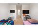 Shared ' bedroom with twin beds, wall-mounted TVs, and an open view down a hallway at 2352 Tay Wes Dr, St Cloud, FL 34771