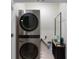 Convenient laundry room with a stacked washer and dryer, and storage shelving at 2352 Tay Wes Dr, St Cloud, FL 34771
