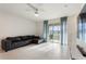 Bright living room with tile flooring, sliding glass doors, and a comfortable black sectional couch at 2352 Tay Wes Dr, St Cloud, FL 34771