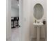 Cozy powder room featuring a pedestal sink, oval mirror, and neutral decor at 2352 Tay Wes Dr, St Cloud, FL 34771