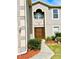 Front entrance with a brown door and landscaping at 2403 Melissa Ann Ct, Kissimmee, FL 34746
