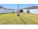 Large grassy backyard featuring a charming brick fire pit area with white fencing at 2472 Deer Creek Blvd, St Cloud, FL 34772