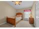 Cozy bedroom with wooden bed frame and a window with curtains at 2542 Bobby Lee Ln, St Cloud, FL 34772