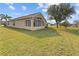Tan house exterior with large sunroom and well-maintained lawn at 2542 Bobby Lee Ln, St Cloud, FL 34772