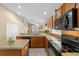 Kitchen features oak cabinets, black appliances, and an island at 2542 Bobby Lee Ln, St Cloud, FL 34772