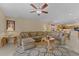 Living room with L-shaped sofa, ceiling fan, and kitchen access at 2542 Bobby Lee Ln, St Cloud, FL 34772