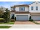 Two-story townhome with gray garage doors and brick driveway at 2935 Rapollo Ln, Apopka, FL 32712