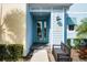 Front entrance with teal door and a black bench, offering curb appeal at 3065 Caribbean Soul Dr, Kissimmee, FL 34747