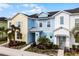 Three-unit townhome building, featuring pastel-colored exteriors and landscaping at 3065 Caribbean Soul Dr, Kissimmee, FL 34747