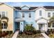 Three-unit townhome building, featuring pastel-colored exteriors and landscaping at 3065 Caribbean Soul Dr, Kissimmee, FL 34747
