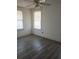 Bedroom with a ceiling fan, wood-look floors, and two windows at 342 E Tillman Ave, Lake Wales, FL 33853