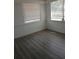 Bedroom with hardwood floor, two windows, and white walls at 342 E Tillman Ave, Lake Wales, FL 33853