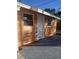 The side of the house shows a clean white door, brown wooden planks, and a gray patio at 342 E Tillman Ave, Lake Wales, FL 33853