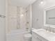 Bright bathroom featuring a shower over tub with decorative tile, vanity with marble countertop, and white fixtures at 4181 Sw 111Th Pl, Ocala, FL 34476
