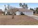 Charming single-story home with a well-maintained front yard, featuring a gray facade, an arched entryway, and a two-car garage at 4181 Sw 111Th Pl, Ocala, FL 34476