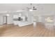 Spacious living room with wood-look flooring, flowing into the kitchen with white cabinetry and granite countertops at 4181 Sw 111Th Pl, Ocala, FL 34476