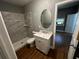 Bathroom featuring a marble tiled shower, oval mirror, and stylish vanity at 433 Pennsylvania Ave, St Cloud, FL 34769