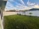 Large backyard with grassy area, trees, and a white vinyl fence at 4702 Greycliff Prairie Dr, Kissimmee, FL 34758