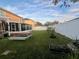 Backyard featuring a screened enclosure, grassy lawn, and a picnic table at 4702 Greycliff Prairie Dr, Kissimmee, FL 34758