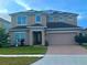 Two-story house with solar panels and a brick paved driveway at 4702 Greycliff Prairie Dr, Kissimmee, FL 34758
