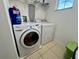 Bright laundry room with washer, dryer, and overhead shelving at 4702 Greycliff Prairie Dr, Kissimmee, FL 34758