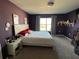 Main bedroom with purple walls, a large bed, and a nightstand at 503 Summer Grove Ln, Haines City, FL 33844