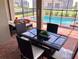 Enjoy al fresco dining on this patio overlooking the pool at 5465 Misty Oak Cir, Davenport, FL 33837