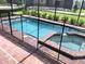 Inviting pool and spa with safety fence, perfect for relaxation at 5465 Misty Oak Cir, Davenport, FL 33837