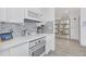 Modern white kitchen with mosaic backsplash and stainless steel appliances at 600 Market St # 210, Celebration, FL 34747