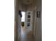 Hallway featuring neutral tile floor, an open door to a washroom, and shelving at 6002 Renaissance Ct, St Cloud, FL 34772