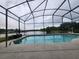 Screened-in pool overlooks a serene lake view, offering a private and relaxing outdoor space at 6002 Renaissance Ct, St Cloud, FL 34772
