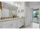 Bathroom with double vanity, white cabinets, and access to a lanai at 641 Pebble Beach Dr, Davenport, FL 33896