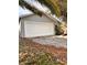Two-car garage with white door and leaf covered driveway at 656 Oakford Way, Orlando, FL 32811