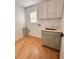 Laundry room with gray cabinets, quartz countertops, and wood-look floors at 656 Oakford Way, Orlando, FL 32811