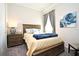 Cozy bedroom with a full-size bed, nightstand, and window at 7637 Sand Pierre Ct, Kissimmee, FL 34747