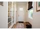 Bright entryway with French doors, hardwood floors and shoe bench at 7637 Sand Pierre Ct, Kissimmee, FL 34747