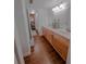 Bathroom featuring double sinks, wood cabinets, and wood-look tile flooring at 768 E Michigan St # 75, Orlando, FL 32806