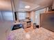 Well-lit kitchen featuring wood-look floors, granite counters, stainless steel appliances, and access to a back door at 768 E Michigan St # 75, Orlando, FL 32806