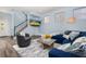 Living area with blue sectional sofa and view of entryway and stairs at 836 Lake Evalyn Dr, Celebration, FL 34747