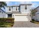 Two-story house with light blue siding, white garage door, and landscaped front yard at 8939 Zurich Ln, Kissimmee, FL 34747