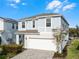 Two-story house with light blue siding, white garage door, and landscaped front yard at 8939 Zurich Ln, Kissimmee, FL 34747