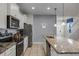Modern kitchen with granite countertops, stainless steel appliances, and an island with seating at 8939 Zurich Ln, Kissimmee, FL 34747