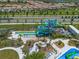 Aerial view of community waterpark area with waterslides, lazy river, lounge chairs, and manicured landscaping at 8976 Azalea Sands Ln # 2604, Davenport, FL 33896