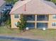 Two-story tan exterior features a tile roof, screened-in balconies, and well-maintained landscaping at 8976 Azalea Sands Ln # 2604, Davenport, FL 33896