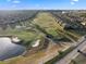 Scenic aerial view of a golf course featuring manicured greens, sand traps, and a pond surrounded by residential homes at 8976 Azalea Sands Ln # 2604, Davenport, FL 33896