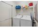 Functional laundry room with washer, dryer, shelving, and accessories for efficient home management at 8976 Azalea Sands Ln # 2604, Davenport, FL 33896