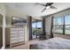 Bright bedroom featuring a dresser, TV, window with blinds, and access to the private balcony with scenic outdoor views at 8976 Azalea Sands Ln # 2604, Davenport, FL 33896